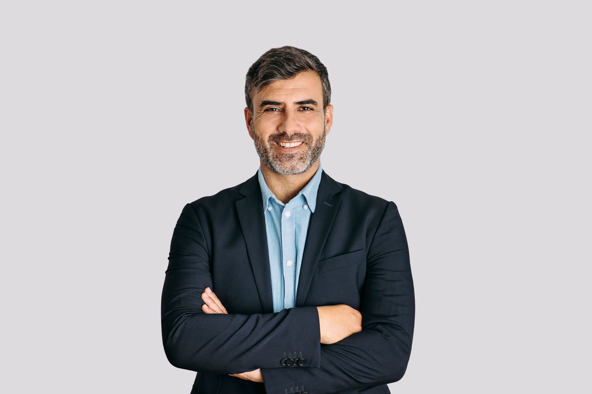 Businessman smiling with arms crossed on white background